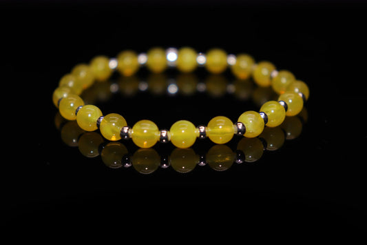 Amber bracelet lifestyle photo radiating golden warmth and healing energy, medieval currency stone turned modern prosperity jewelry accessory