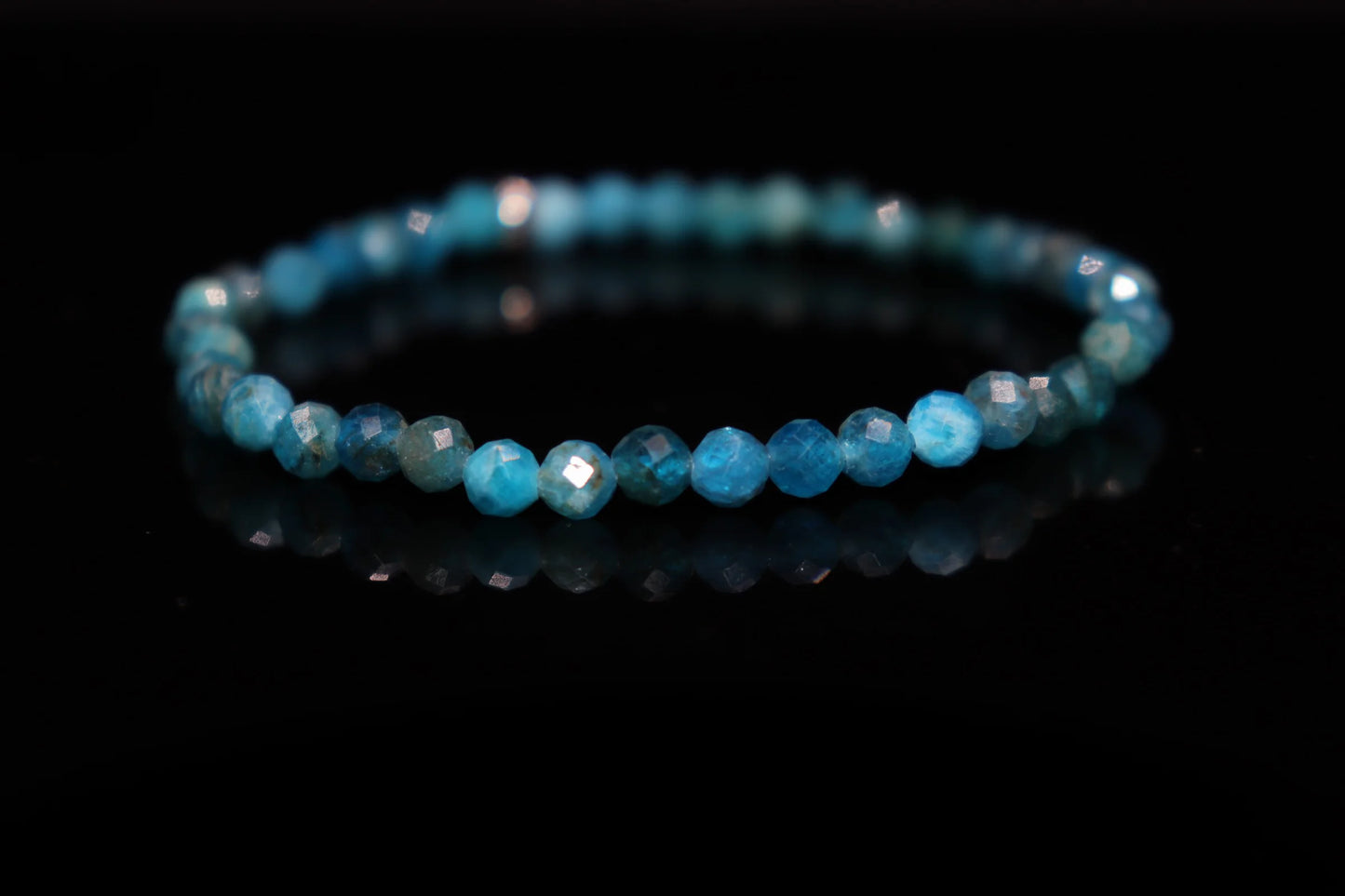 Close-up detail of blue apatite bracelet showing intense vivid blue gemstone clarity, medieval spiritual fire divine communication stone jewelry