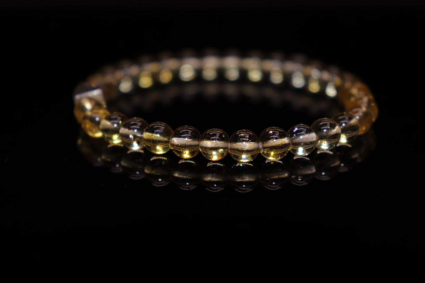 Close-up detail of citrine bracelet showing brilliant sunny golden clarity and natural sparkle, ancient Greek god statue protective gemstone jewelry