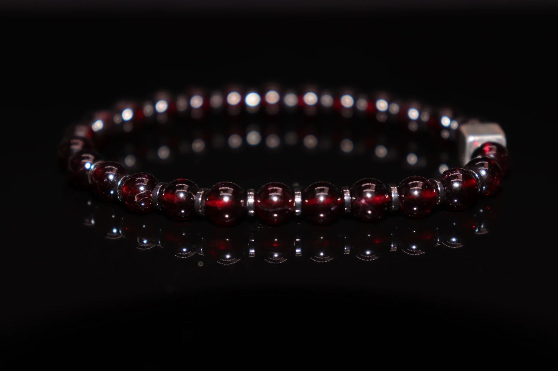 Close-up detail of garnet bracelet showing rich pomegranate red crystal clarity, Victorian-era love token and Roman soldier victory amulet gemstone jewelry