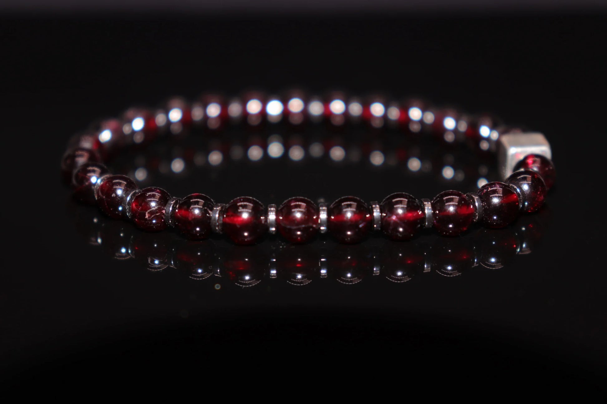 Garnet silver bracelet worn on wrist, January birthstone jewelry of protection and eternal love, crusader armor talisman healing accessory