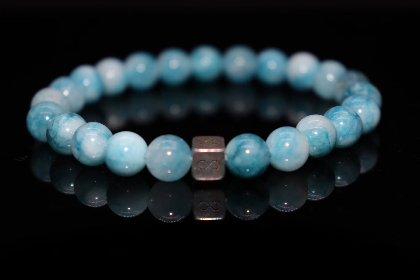 Close-up detail of larimar bracelet showing blue and white wave-like patterns, Virgin Mary mantle sea protection stone texture jewelry