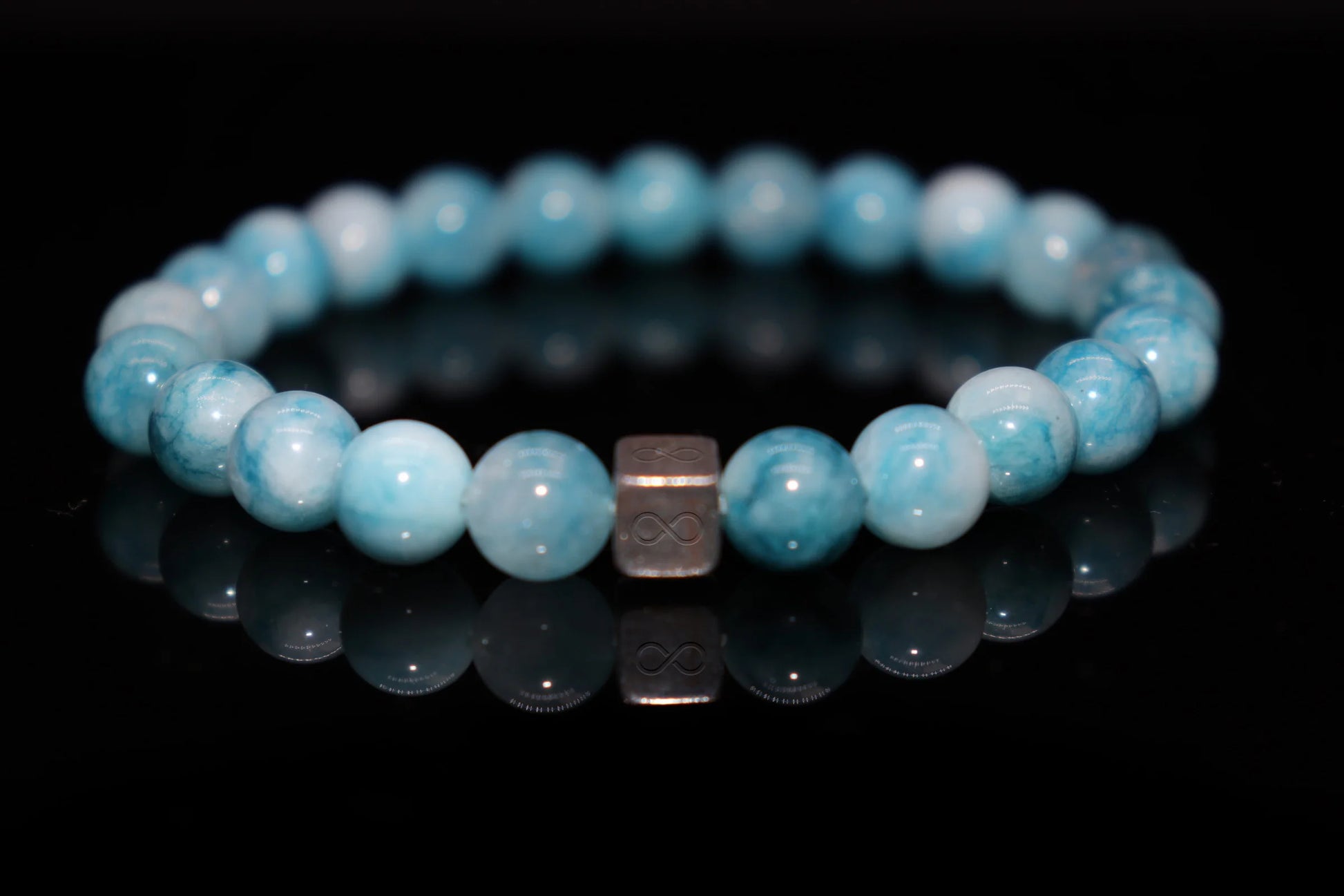 Close-up detail of larimar bracelet showing blue and white wave-like patterns, Virgin Mary mantle sea protection stone texture jewelry