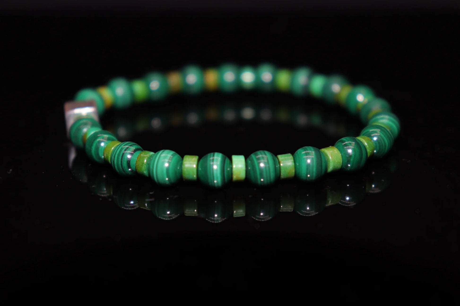 Close-up detail of malachite bracelet showing natural green eye-like concentric rings texture, eye of God protection amulet gemstone jewelry