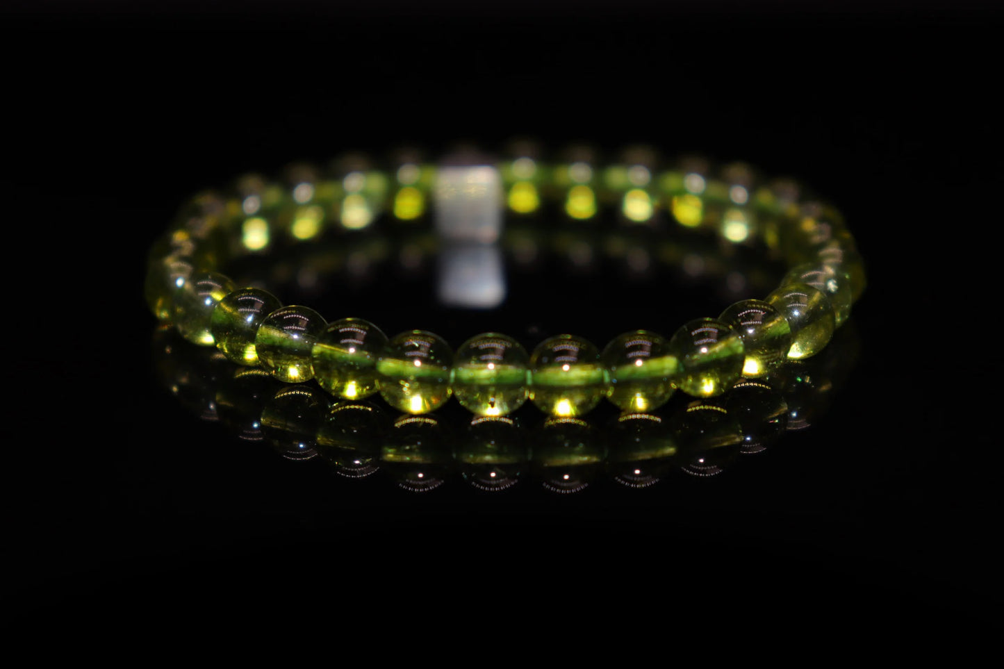Close-up detail of peridot bracelet showing brilliant olive green crystal clarity and natural texture, sun god Ra gemstone jewelry