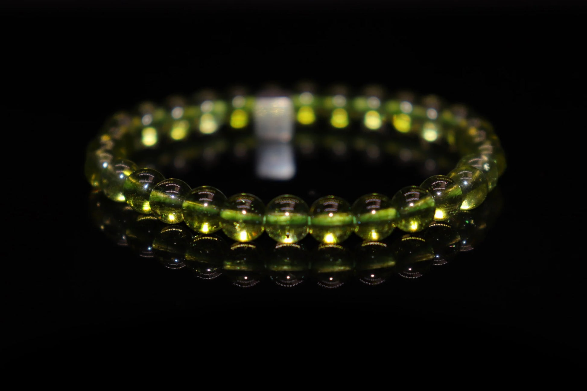 Close-up detail of peridot bracelet showing brilliant olive green crystal clarity and natural texture, sun god Ra gemstone jewelry