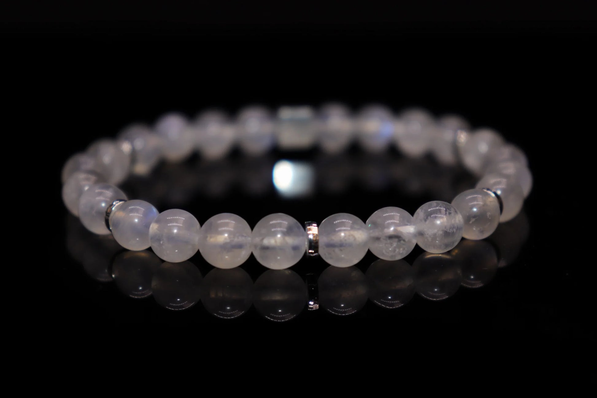 Close-up detail of white moonstone bracelet showing mesmerizing blue-white sheen and adularescence effect, Diana Selene sacred gemstone jewelry